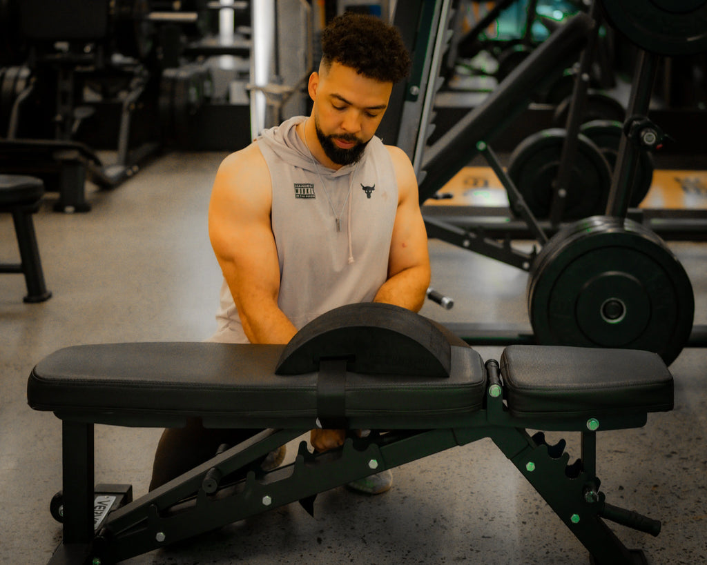 Anthony Nitti securing the EZBack Pro Level 3 strap onto a flat bench, demonstrating setup for advanced posture support and spinal engagement.