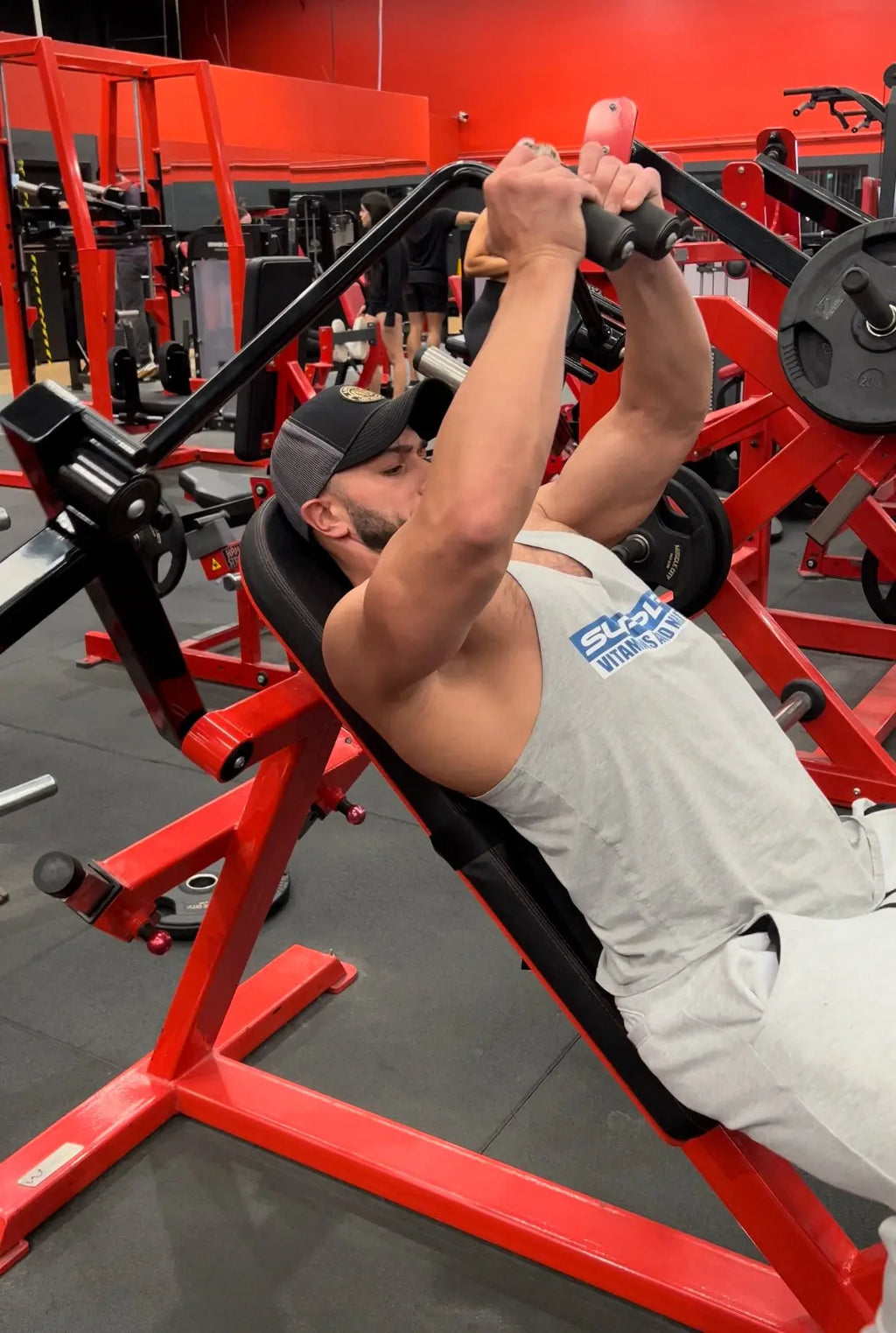 Flip Gordon using a chest fly machine with the EZBack Pro Level 2 strap attached to the back pad to maintain posture and enhance mid-back support.